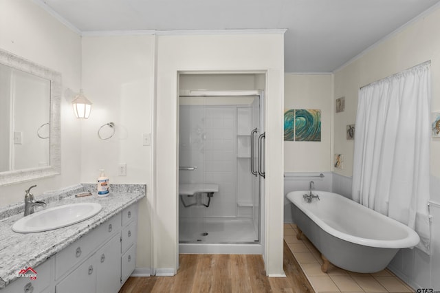 bathroom with plus walk in shower, crown molding, vanity, and wood-type flooring