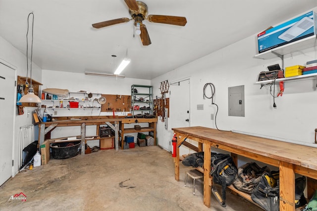 garage featuring ceiling fan, electric panel, and a workshop area