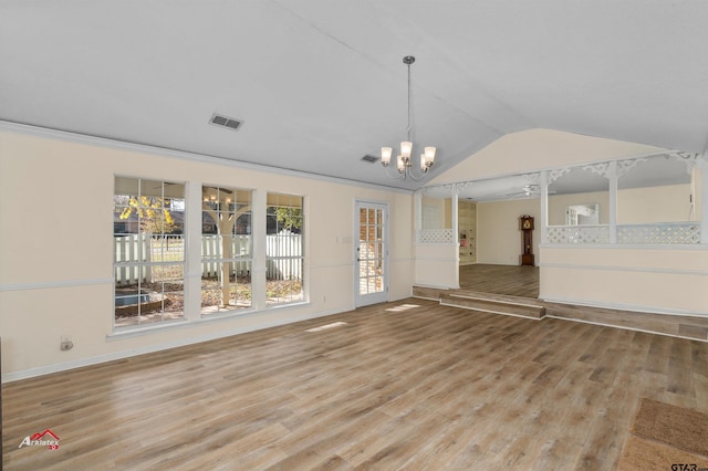 interior space featuring lofted ceiling, an inviting chandelier, ornamental molding, and light hardwood / wood-style flooring