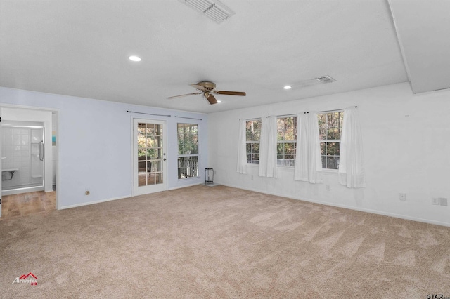 unfurnished living room with ceiling fan, light colored carpet, and a healthy amount of sunlight