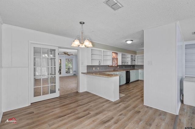 kitchen featuring light hardwood / wood-style floors, kitchen peninsula, pendant lighting, black dishwasher, and white cabinetry