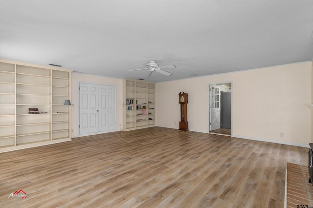 unfurnished living room featuring a textured ceiling, built in features, ceiling fan, and light hardwood / wood-style flooring