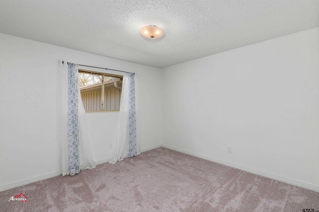 carpeted empty room featuring a textured ceiling