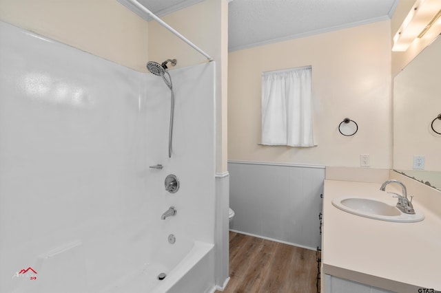 full bathroom featuring toilet, wood-type flooring, crown molding, vanity, and shower / bath combination