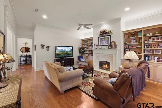 4007 Spartanburg Ln, Tyler, TX 75701 - living room with crown molding, ceiling fan, light wood-style floors, a warm lit fireplace, and recessed lighting