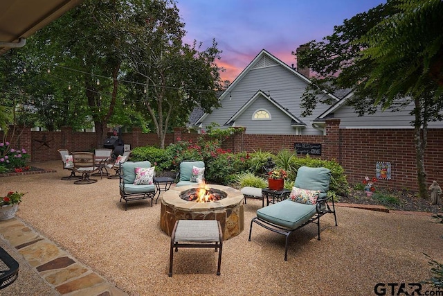 4007 Spartanburg Ln, Tyler, TX 75701 - patio terrace at dusk featuring an outdoor fire pit, a patio area, and a fenced backyard