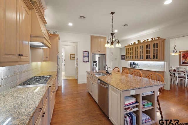 4007 Spartanburg Ln, Tyler, TX 75701 - kitchen featuring stainless steel appliances, a sink, a kitchen breakfast bar, backsplash, and a center island with sink