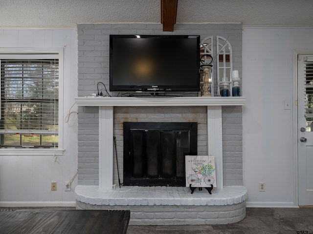 details with beamed ceiling, a fireplace, and a textured ceiling