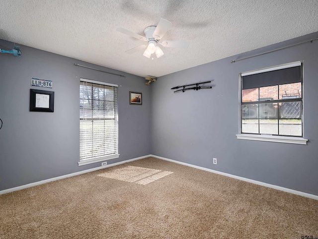 unfurnished room with ceiling fan, carpet floors, and a textured ceiling