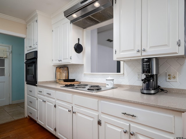 kitchen featuring white cabinets, decorative backsplash, oven, and range hood