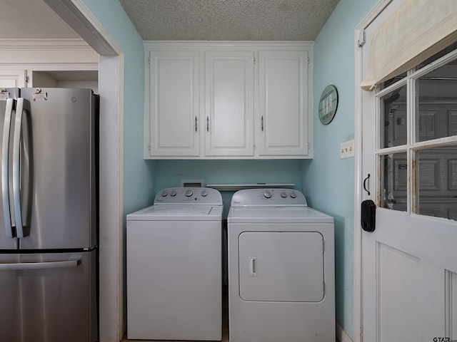 clothes washing area featuring independent washer and dryer, cabinets, and a textured ceiling