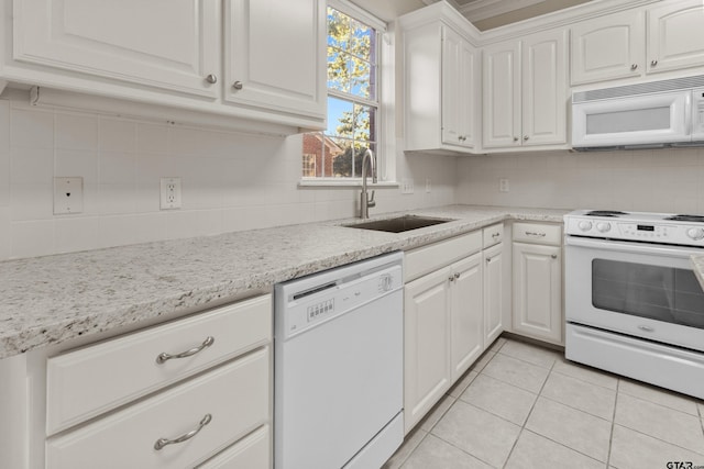 kitchen featuring light tile patterned floors, decorative backsplash, sink, white cabinets, and white appliances