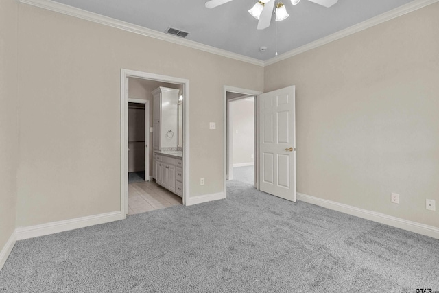 unfurnished bedroom with ornamental molding, ceiling fan, ensuite bath, and light colored carpet