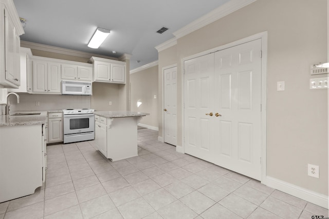 kitchen with a kitchen island, white appliances, light stone counters, and white cabinets