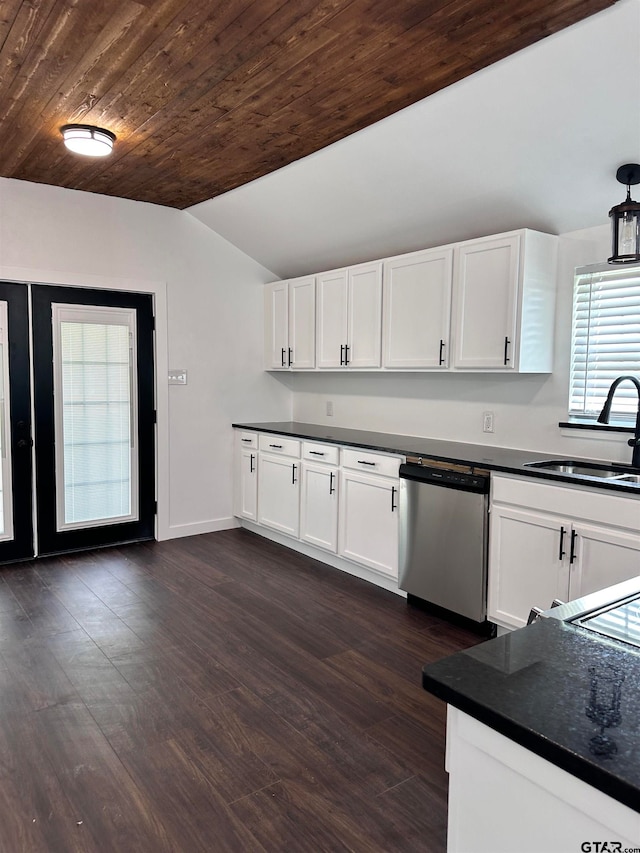 kitchen featuring dark countertops, stainless steel dishwasher, white cabinetry, vaulted ceiling, and a sink