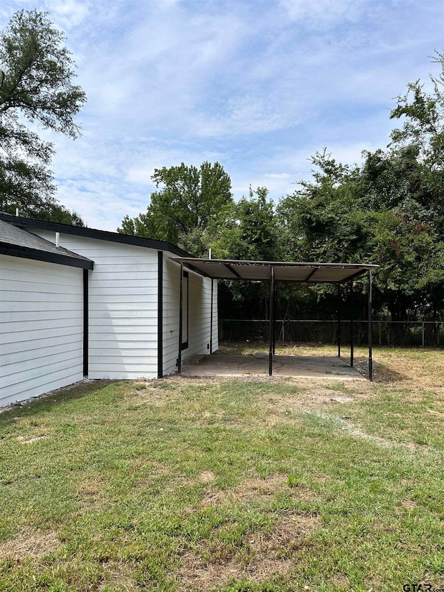 view of yard featuring fence and an attached carport