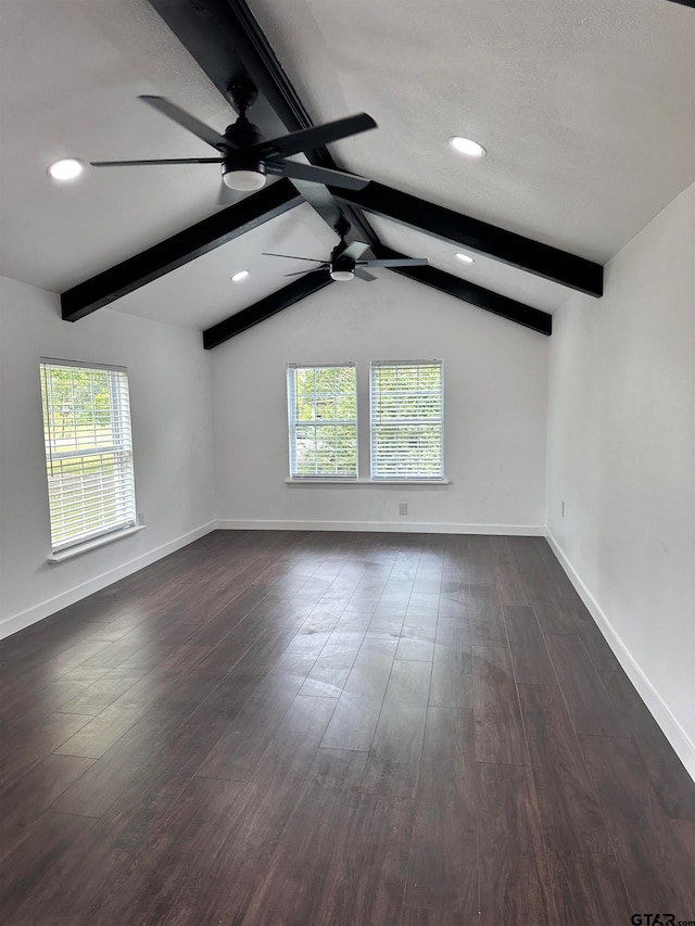 unfurnished room with a healthy amount of sunlight, lofted ceiling with beams, baseboards, and dark wood-type flooring