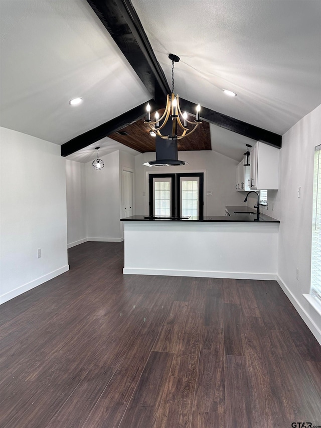 interior space featuring dark wood-type flooring, dark countertops, white cabinetry, and baseboards