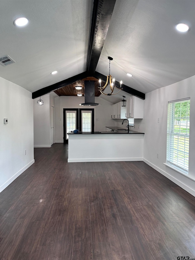 unfurnished living room with dark wood finished floors, visible vents, vaulted ceiling with beams, and baseboards