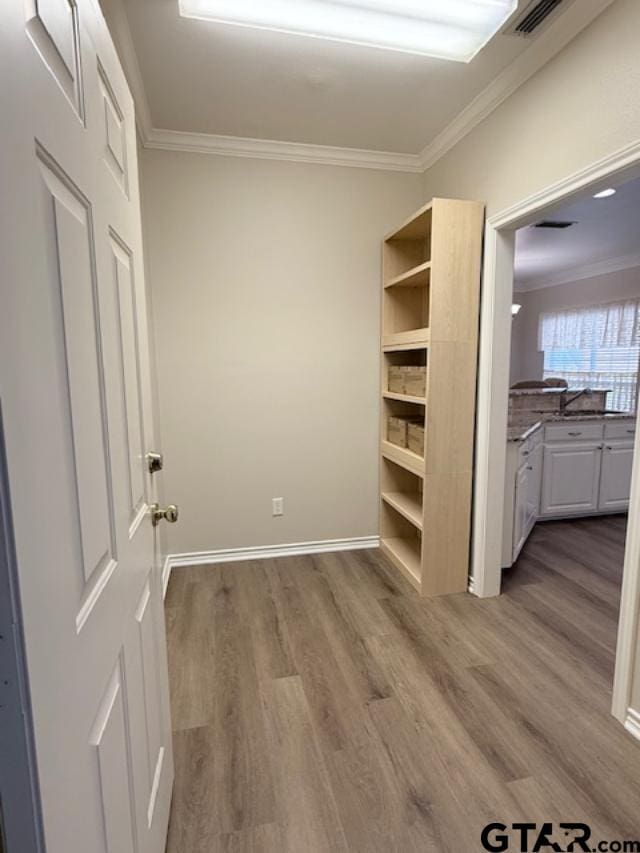 interior space featuring light hardwood / wood-style floors and crown molding