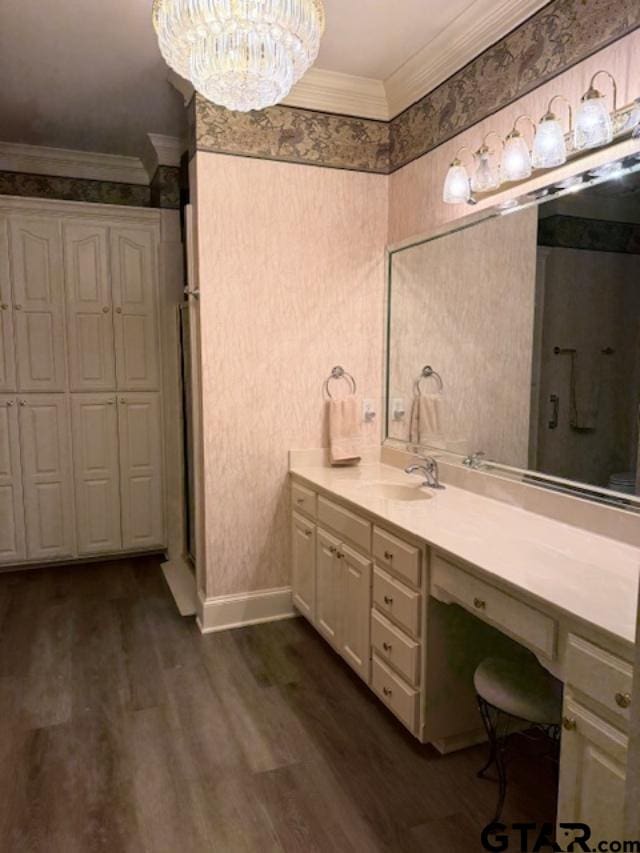 bathroom featuring hardwood / wood-style floors, vanity, a chandelier, and ornamental molding