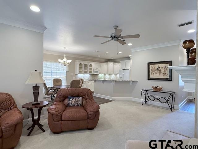 living room featuring light carpet, ceiling fan with notable chandelier, and ornamental molding