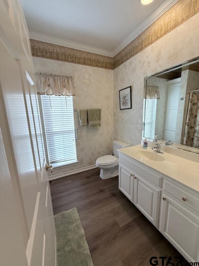 bathroom with hardwood / wood-style flooring, vanity, toilet, and ornamental molding