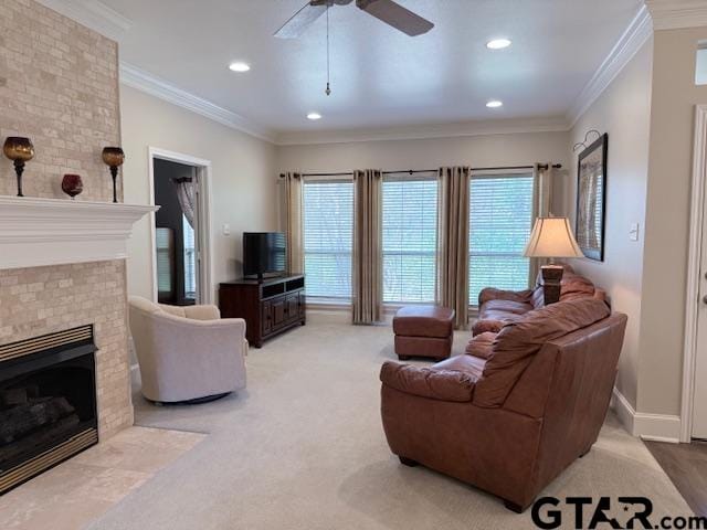 carpeted living room featuring ceiling fan, crown molding, and a fireplace