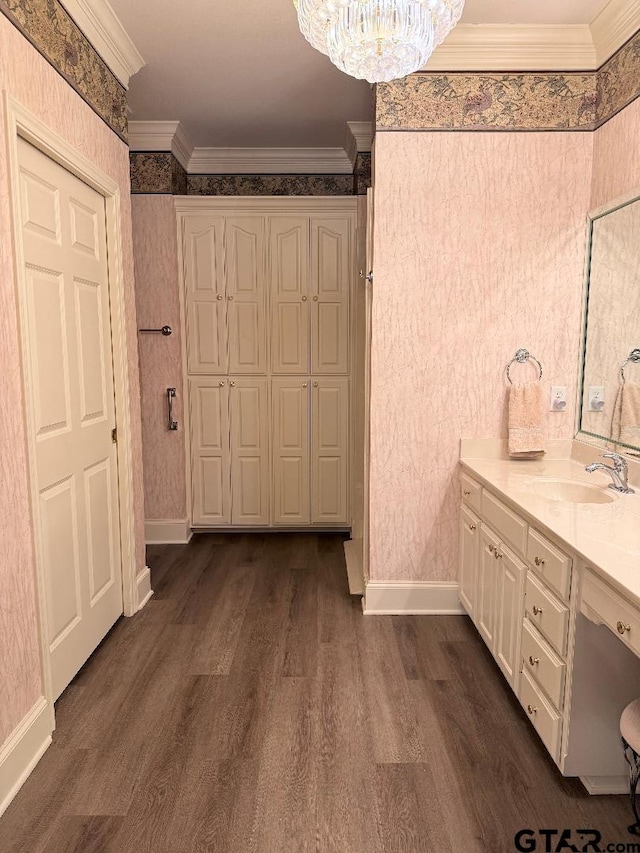 bathroom featuring hardwood / wood-style floors, vanity, crown molding, and a chandelier