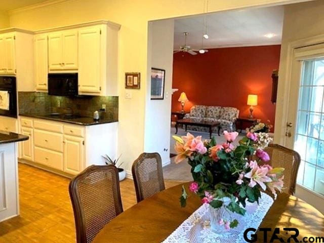 dining room with ornamental molding and light wood-type flooring