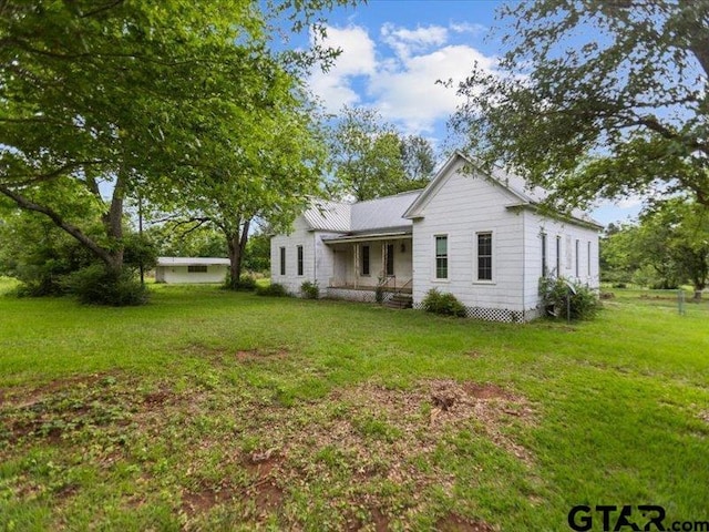 back of house featuring a lawn and a porch