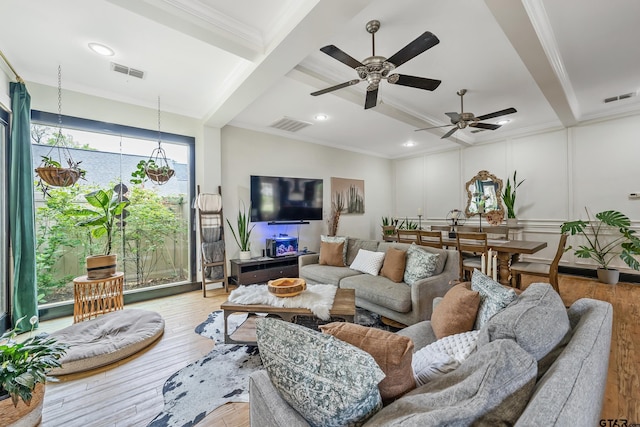 living area with beamed ceiling, visible vents, and crown molding