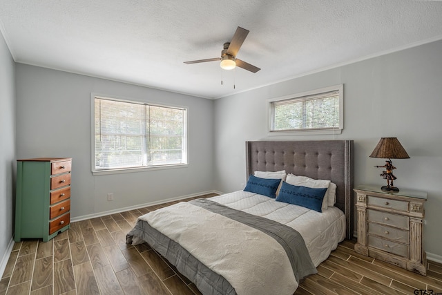 bedroom with baseboards, a ceiling fan, wood finish floors, and a textured ceiling