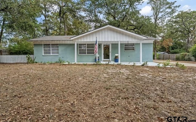 ranch-style home featuring fence and brick siding