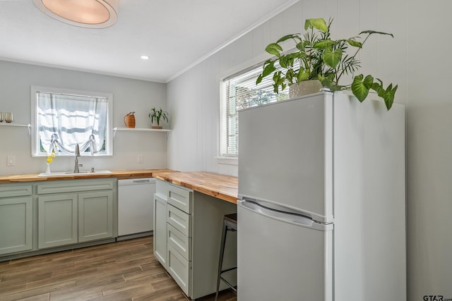 kitchen featuring crown molding, open shelves, butcher block counters, wood finished floors, and white appliances