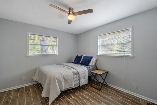 bedroom featuring wood tiled floor, a ceiling fan, and baseboards