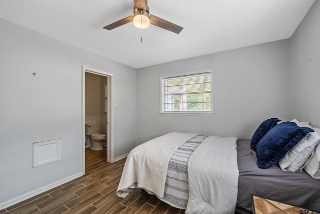 bedroom featuring ensuite bathroom, a ceiling fan, dark wood-style floors, and baseboards
