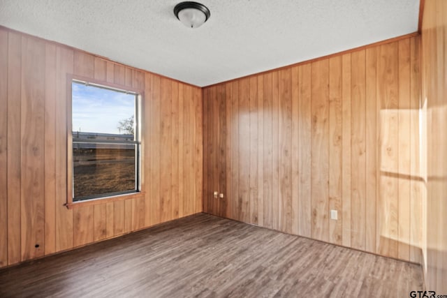 empty room featuring dark hardwood / wood-style floors and wood walls