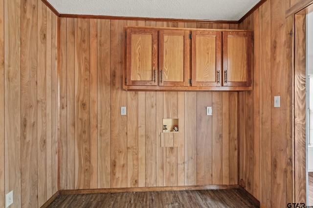 washroom featuring washer hookup, wooden walls, cabinets, and a textured ceiling