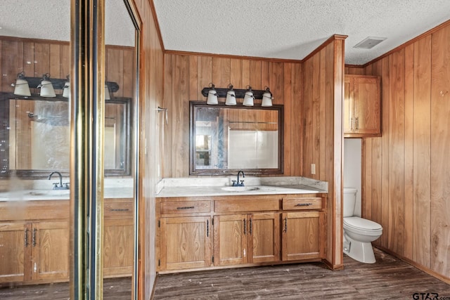 bathroom featuring vanity, toilet, wood-type flooring, and wood walls