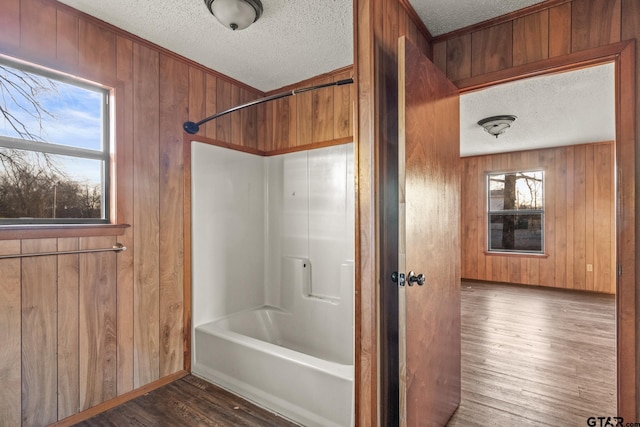 bathroom featuring wood-type flooring, a textured ceiling, and wooden walls