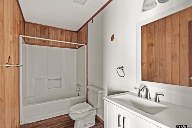 full bathroom with washtub / shower combination, hardwood / wood-style floors, vanity, a textured ceiling, and toilet