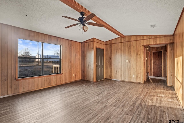 unfurnished living room with hardwood / wood-style flooring, ceiling fan, vaulted ceiling with beams, and a textured ceiling