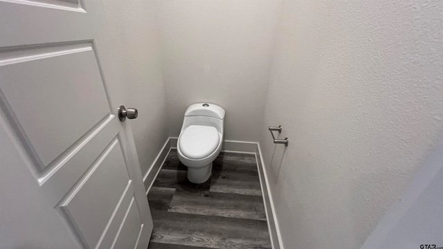 bathroom with toilet and hardwood / wood-style floors