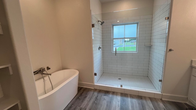 bathroom featuring hardwood / wood-style flooring and plus walk in shower