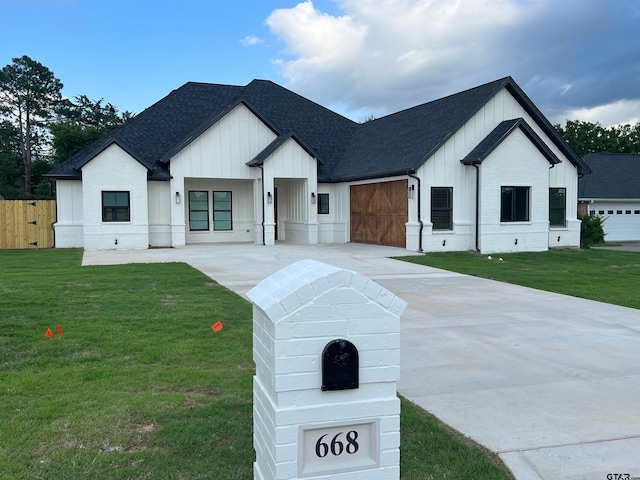 modern inspired farmhouse with a garage and a front lawn