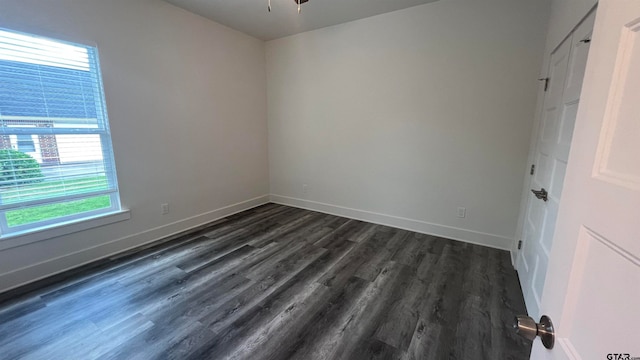 empty room with dark hardwood / wood-style flooring