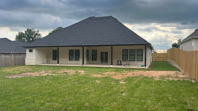 back of house with a lawn and a patio area