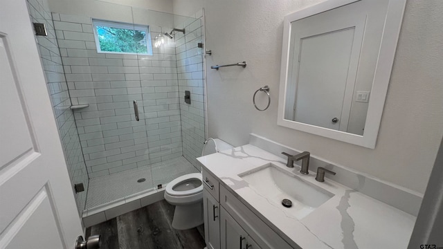 bathroom featuring toilet, an enclosed shower, vanity, and wood-type flooring