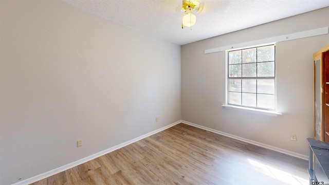 empty room featuring light hardwood / wood-style floors, ceiling fan, and a textured ceiling